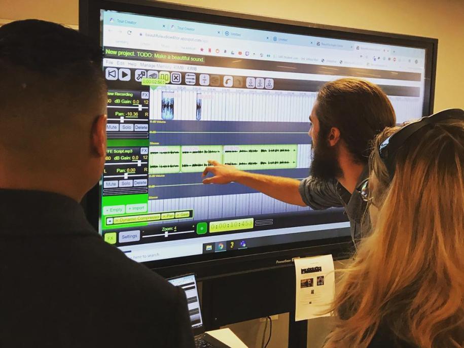 Photo of people looking at a screen with educational technology software.