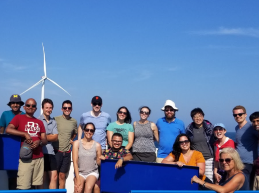 student on boat by offshore wind turbine