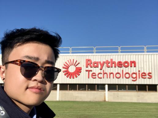 Jabin Chen in sunglasses in front of Raytheon technologies sign
