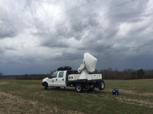 Storm tracking apparatus attached to back of a truck; ominous storm cloud