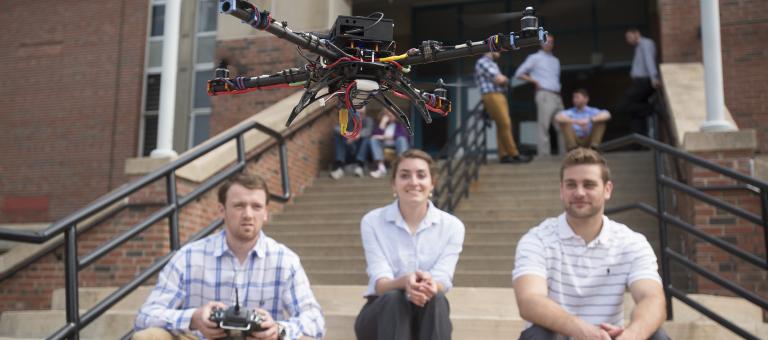 Students on steps flying drone