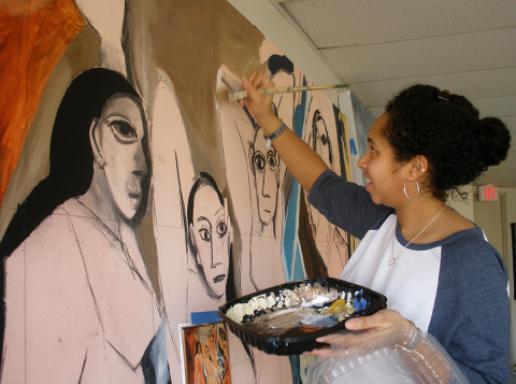 A University of Massachusetts student paints a scene on a canvas
