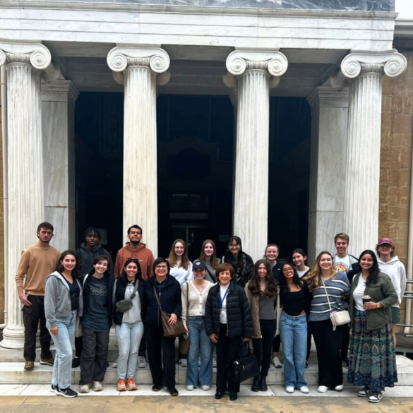 Students from UMass Amherst standing in front of a building in Cyprus during the Winter Study Abroad Program