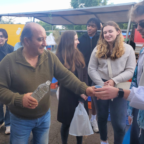 A man sharing water with UMass students in Cyprus
