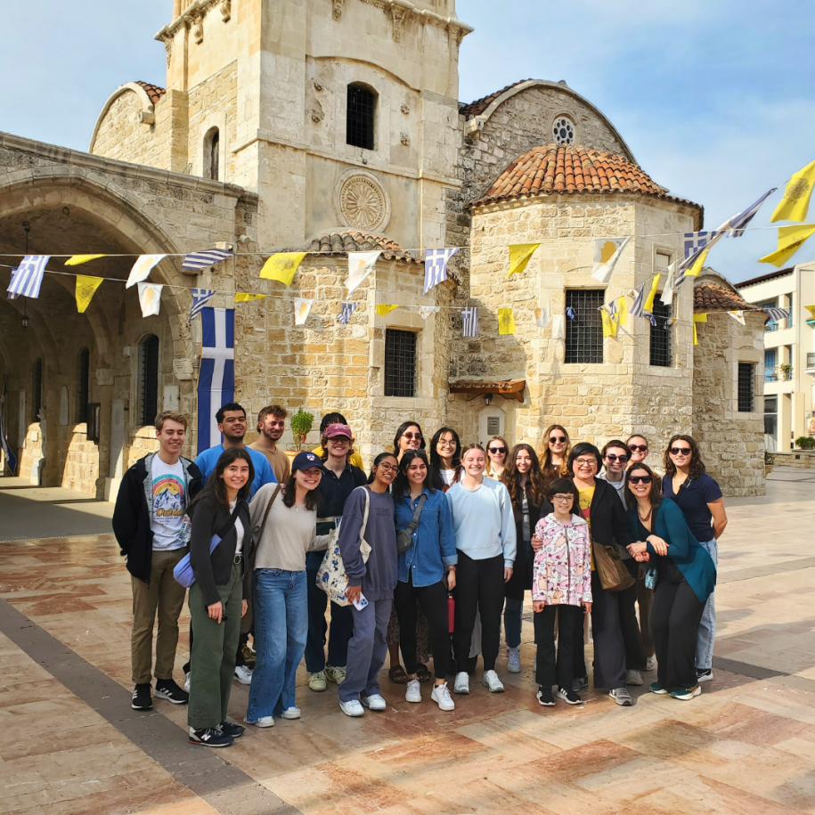 Photo of UMass Amherst students posing in front of a building in Cyprus