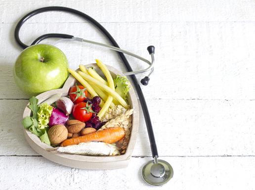Fruits and veggies arranged in a heart shape surrounded by a stethoscope