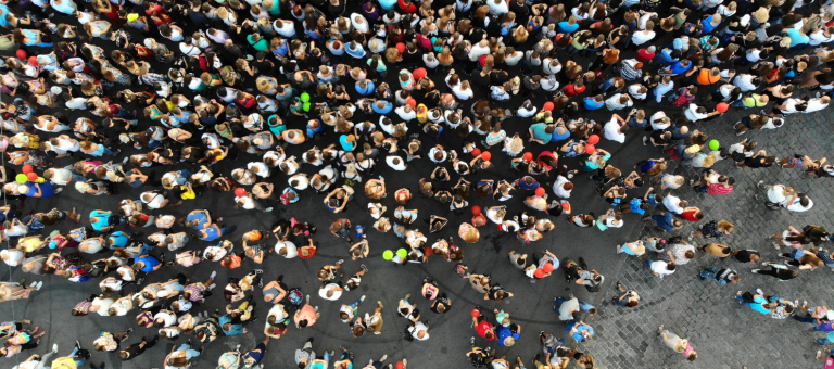 Bird's eye view of a large group of people gathered on a street in a city